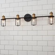 a bathroom light that is on the side of a white brick wall with four lights