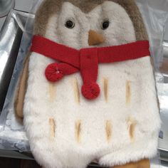 a stuffed owl with a red ribbon around its neck sitting on top of some tin foil