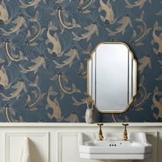 a white sink sitting under a bathroom mirror next to a wall mounted faucet