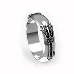 a silver ring with an intricate design on the front and side, sitting against a white background