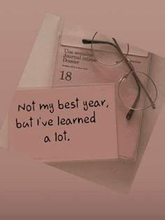 a pair of glasses sitting on top of a piece of paper with the words, not my best year, but i've learned a lot