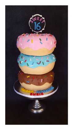 three donuts stacked on top of each other with a happy 16th birthday sign above them