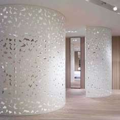 the inside of a room with white walls and wooden floors, decorated with intricate laser cut screens