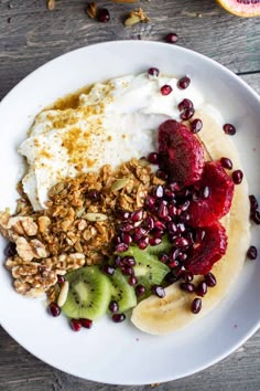 a white plate topped with granola, fruit and yogurt