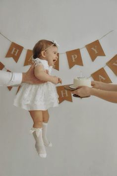 a woman holding a cake with a baby on her lap