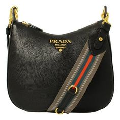 This Prada handbag is a perfect everyday bag. Pebbled black leather paired with orange and blue web stripe nylon strap. The gold Prada logo looks amazing with the black leather. The strap pairs with the classic black leather to add a pop of color to your everyday wardrobe. Wear as a shoulder bag, or as a crossbody. Model: 1BC166 - 1BC052 Black Vitello Phenix leather Gold-tone hardware Top zip closure One interior zip pocket One interior slip pocket Interior signature Prada nylon jacquard lining Adjustable/ Detachable nylon shoulder strap Strap drop: 17-21" Measurements: 12 x 3 x 10" (LWH) Includes authenticity cards and Prada dust bag Made in Italy Size: one size.  Gender: female.  Age Group: adult. Dressy Hats, Total Girl, Prada Purses, Prada Handbag, Bag Obsession, Prada Nylon, Prada Logo, Prada Handbags, Big Bags