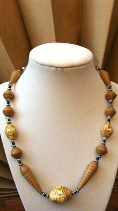 a necklace with wooden beads on a mannequin