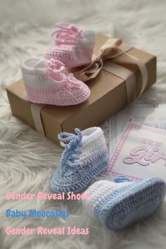 two baby booties are sitting next to a box