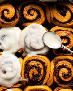 cinnamon rolls with icing on top in a pan