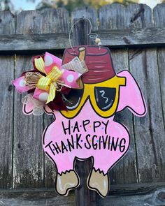 a pink and yellow sign that says happy thanksgiving with a turkey wearing sunglasses on it