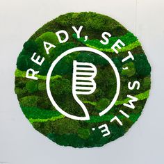 A round moss logo made for a dental office with their slogan Wall Moss, Moss Walls