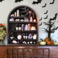 a wooden shelf filled with lots of different items on top of a mantle covered in bats