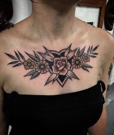 a woman's chest with flowers and geometric shapes on her upper half - arm