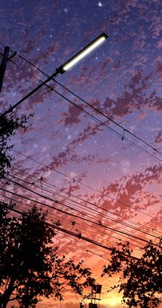 the sky is filled with stars and clouds at night, as seen from behind power lines