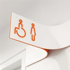 an orange and white bathroom sign on the wall