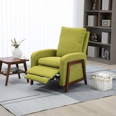 a green recliner chair sitting on top of a rug next to a wooden table