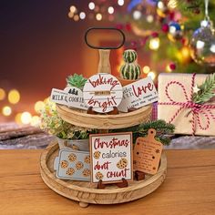 three tiered tray with christmas cookies and holiday cards on it, next to presents