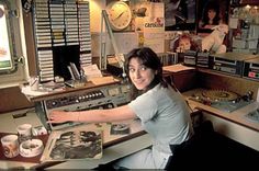 a woman sitting at a desk in front of a record player