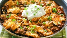 a skillet filled with taco meat and sour cream