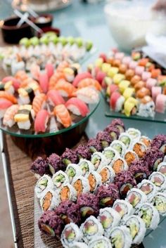 an assortment of sushi and other food items on a table with a video player