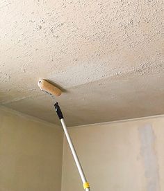 a mop is hanging from the ceiling in a room that has been painted white