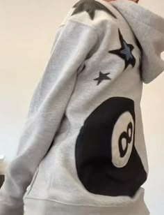 a young boy wearing a sweatshirt with a number on the front and stars on the back