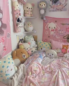 there are many stuffed animals on the wall above the bed and in the corner is a pink blanket