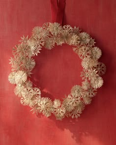 a gold wreath is hanging on a red wall