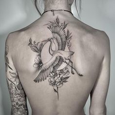 the back of a woman's body with tattoos on her upper and lower back