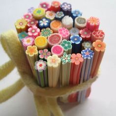 a bunch of pencils that are sitting in a vase with flowers on them,