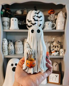 a person holding up a fake ghost with a pumpkin in it's mouth and eyes