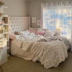 a bedroom with a bed, dresser and window in the corner that has curtains on both sides