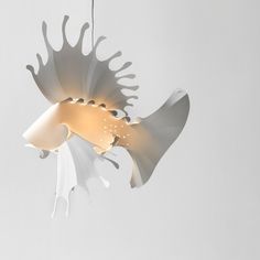 a fish shaped light hanging from a ceiling