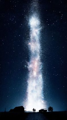 two people are standing under the stars in the night sky, looking up at the milky