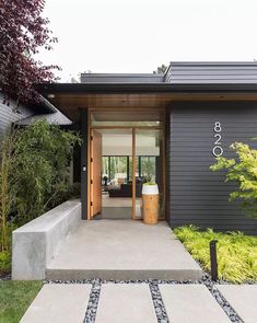 the entrance to a modern home with stone steps leading up to it's front door