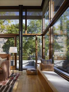 a living room filled with furniture and windows next to a wooden floor covered in lots of windows