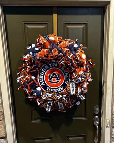 an orange and black front door wreath with the auburn tigers on it