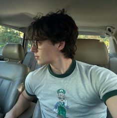 a young man sitting in the back seat of a car with his head turned to the side