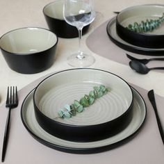 a table set with plates, silverware and wine glasses