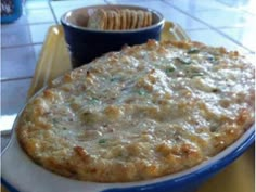 a casserole dish is shown with a fork in the foreground and a blue bowl on the right side