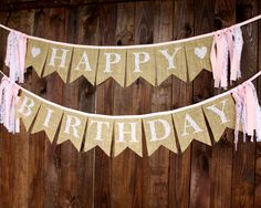 a happy birthday banner hanging on a wooden fence