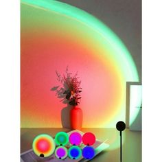 a vase filled with flowers sitting on top of a table next to neon colored balls