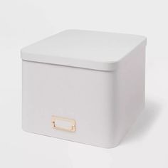 a white storage box with gold handles on the top and bottom, against a white background