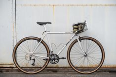 a white bike parked next to a metal wall