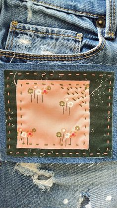 a patch in the back pocket of someone's jean pants with flowers on it