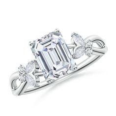 an emerald cut diamond ring with two diamonds on the band