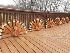 several wooden turkeys on a deck with trees in the background