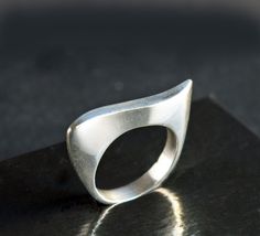 Elegant classic ring featuring a modernist wave design. The ring's fluid curves make an abstract art statement and it has a beautiful handmade look and feel. The ring's inner diameter is about 18.14, making the size a US size 8. The band measures 4 mm wide and is marked 925. The silver band has a few tiny nicks and scratches, consistent with wear and age. When wearing the ring, you don't notice these scratches - what you notice is the beauty of the ring's design and the excellent craftsmanship. Please zoom in each picture to see the tiny dings and scratches that are naturally acquired over time. These can be polished out, however, such marks are part of the ring's history and I'd recommend that you leave the marks and add your own personality and history to the piece :)  The pictures in my Modern Curved Rings With Polished Finish, Modern Wavy Rings With Polished Finish, Modern Silver Wavy Rings, Modern Curved Jewelry With Polished Finish, Modern Wavy Jewelry For Formal Occasions, Wax Tutorial, Abstract Ring, Modern Silver Ring, Art Statement