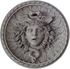 the face of a woman with a snake on her head is depicted in this decorative wall plaque