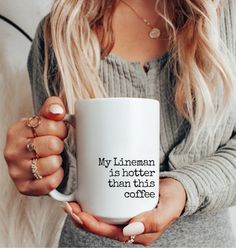 a woman holding a white coffee mug with the words, my lineman is shorter than this coffee